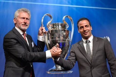 Former players Germany's Paul Breitner (L), representing Bayern Munich and France's Ludovic Giuly, representing Barcelona, pose with The UEFA Champions League trophy on stage after the draw for the UEFA Champions League semi-final football matches at the UEFA headquarters in Nyon on April 24, 2015. AFP PHOTO / FABRICE COFFRINI        (Photo credit should read FABRICE COFFRINI/AFP/Getty Images)