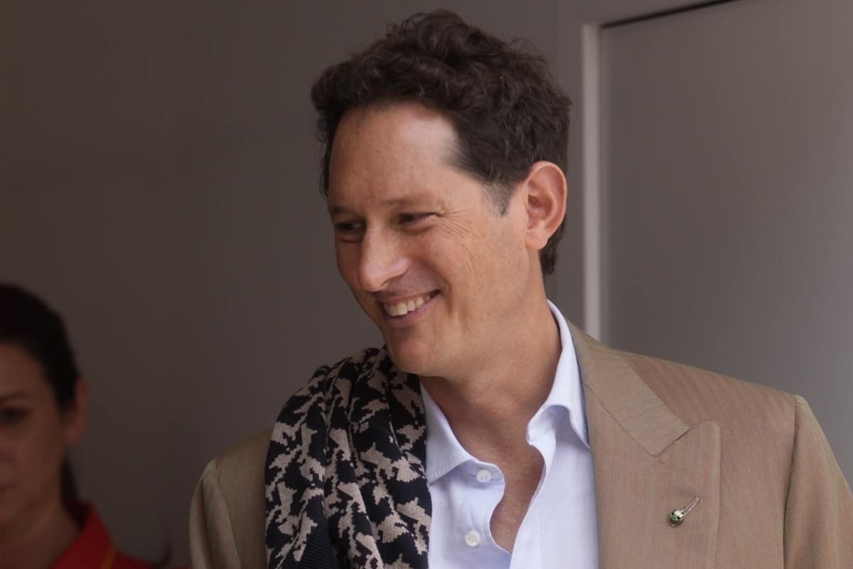 John Elkann in primo piano, sorridente e con sguardo di lato